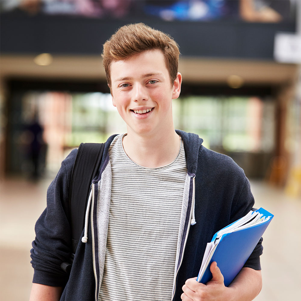portrait-of-male-student-standing-in-college-build-PQG6E9T.jpg